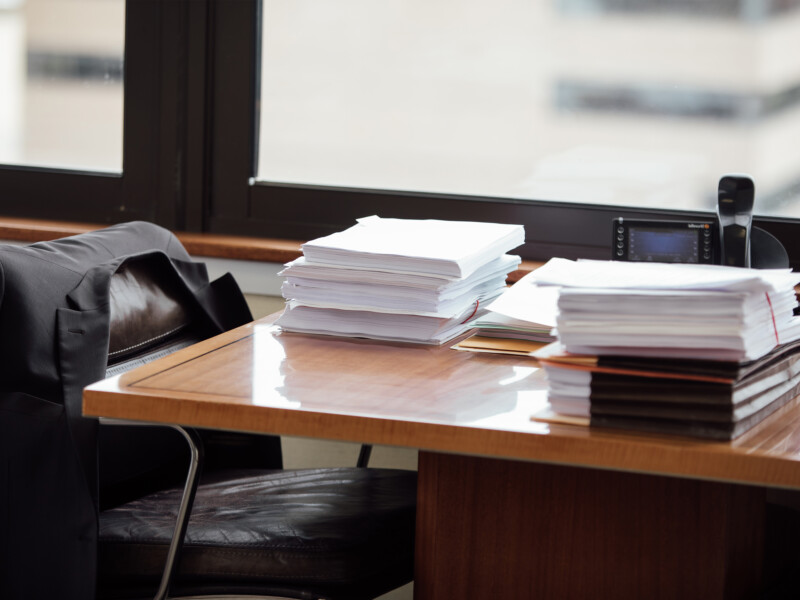 work desk with stacks of papers and contracts