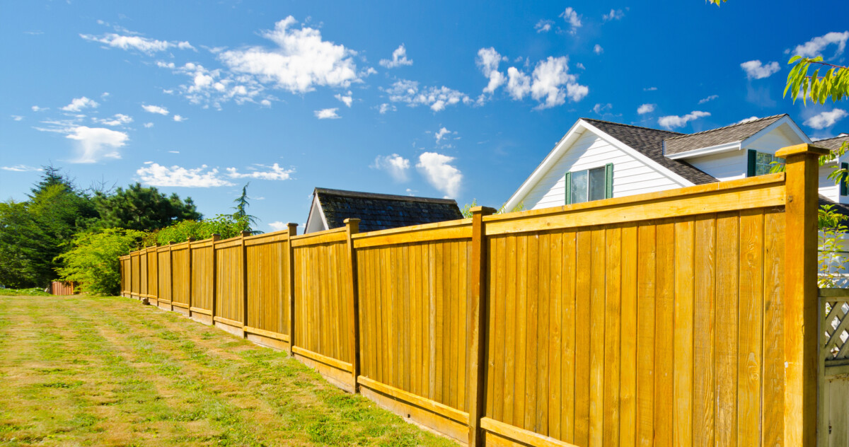 Wooden fence marking a property's boundary line.