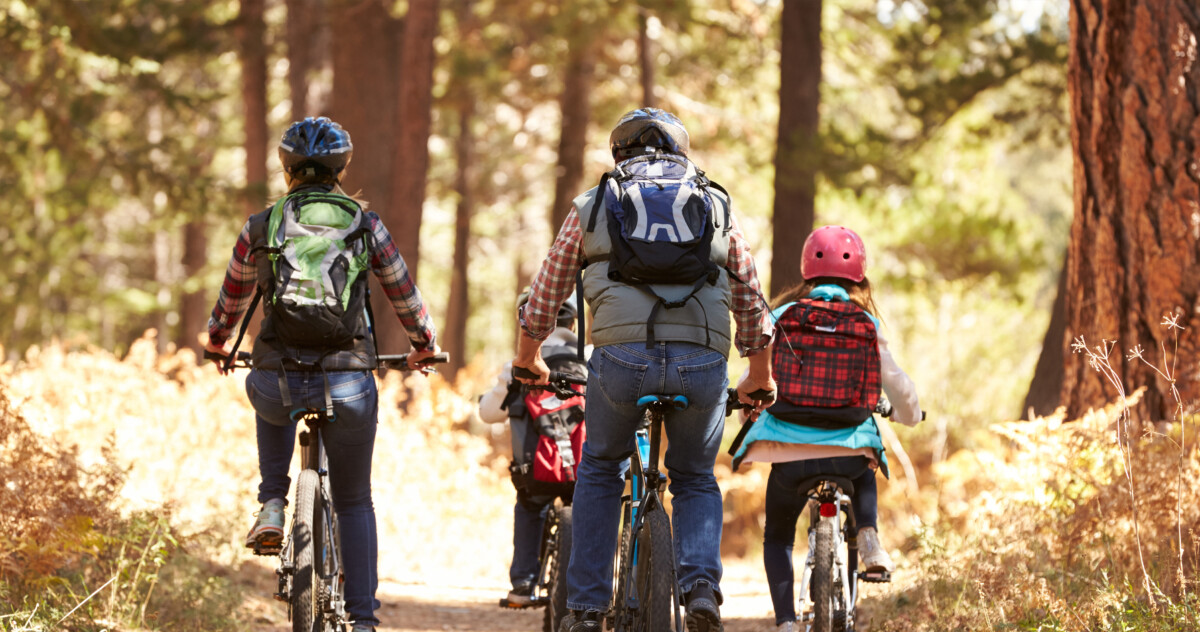 A family biking on a community bike path through the woods